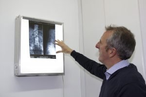El doctor en quiropráctica Richard Millo analiza una columna vertebral antes de realizar un ajuste quiropráctico