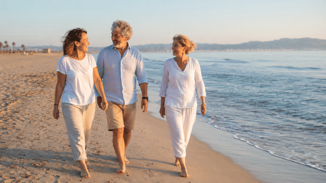 Adultos caminando por la playa para mantenerse activos